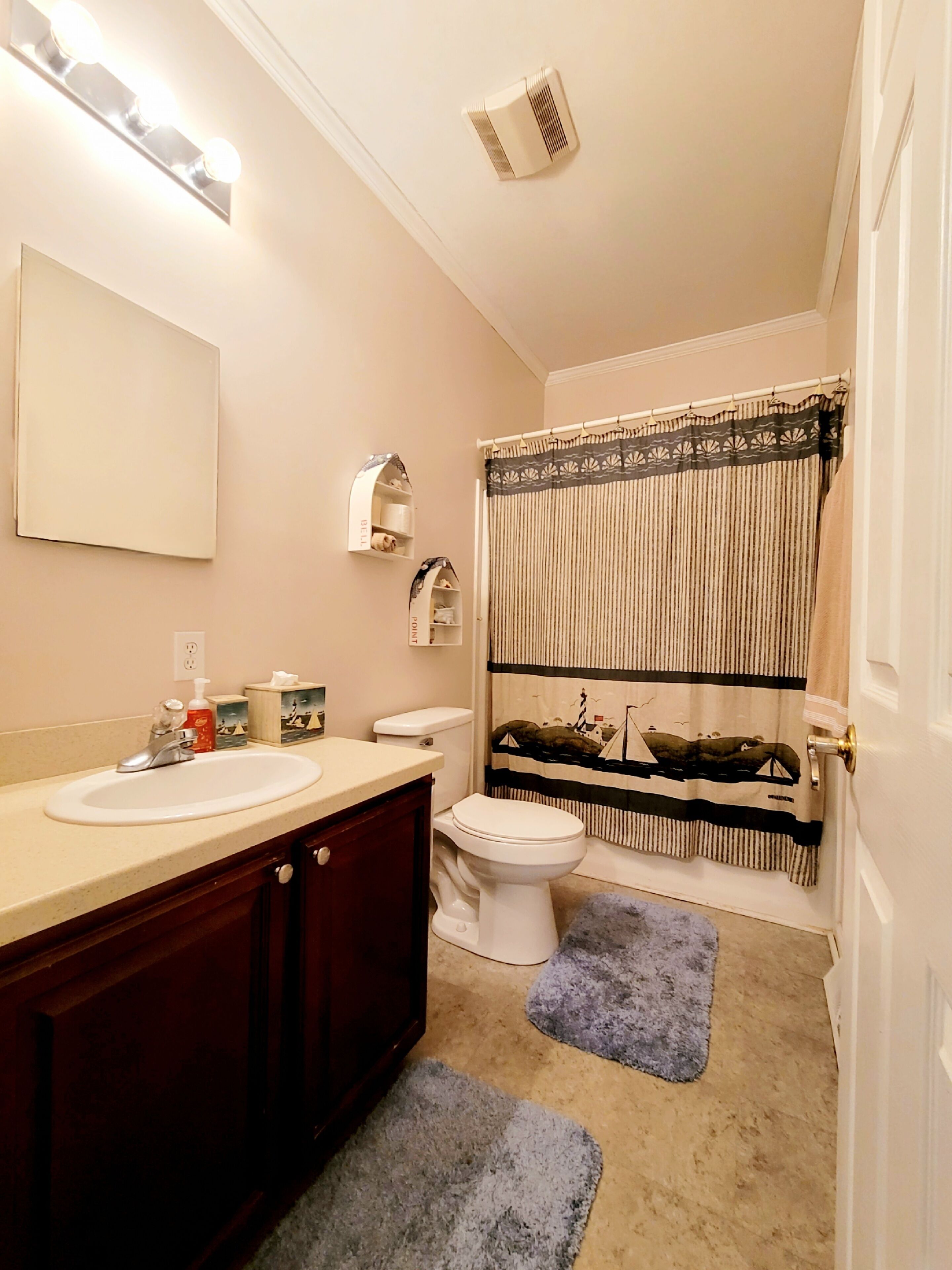 Baño con lavamanos, inodoro y cortina de ducha.