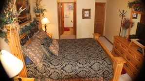 A bedroom with a bed, dresser, lamp, and a door leading to another room. - Family Friendly 3 Bedroom, 3 Bath, Mt. Home, Close To 6 World Famous Ski Areas (Dillon)