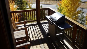 A wooden deck with a barbecue grill, overlooking a residential area with autumn foliage and houses. - Family Friendly 3 Bedroom, 3 Bath, Mt. Home, Close To 6 World Famous Ski Areas (Dillon)