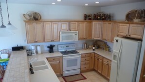 A kitchen with wooden cabinets, a microwave, a stove, a refrigerator, and various kitchen appliances. - Family Friendly 3 Bedroom, 3 Bath, Mt. Home, Close To 6 World Famous Ski Areas (Dillon)