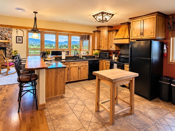 A kitchen with wooden cabinets, a black refrigerator, and a dining area with a wooden table and chairs.