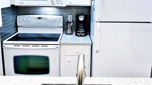 A kitchen with a stainless steel sink, a microwave, a coffee maker, and a refrigerator. - 🌟Updated Fairfield Glade Condo 🌟w/King Size bed, pet friendly, Wifi, & more! (Crossville)