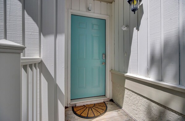 A turquoise door with a doormat and a small porch area. - Award-Winning Resort Amenities | Racquet Club Villa 28 (Isle of Palms)