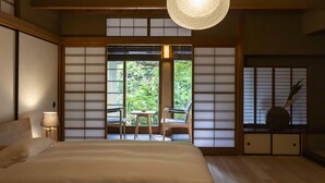 A traditional Japanese-style bedroom with tatami flooring, a bed, a desk, and a chair. - Kazeno Naramachi (Nara)