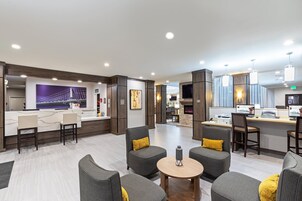 Un moderno vestíbulo de hotel con una recepción, zona de estar y una chimenea.