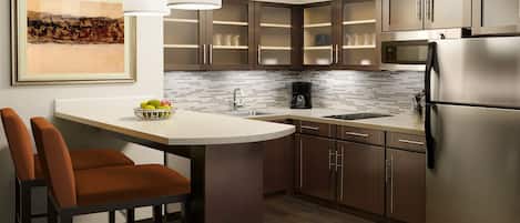 Una cocina moderna con una isla central, electrodomésticos de acero inoxidable y un salpicadero de azulejos.
