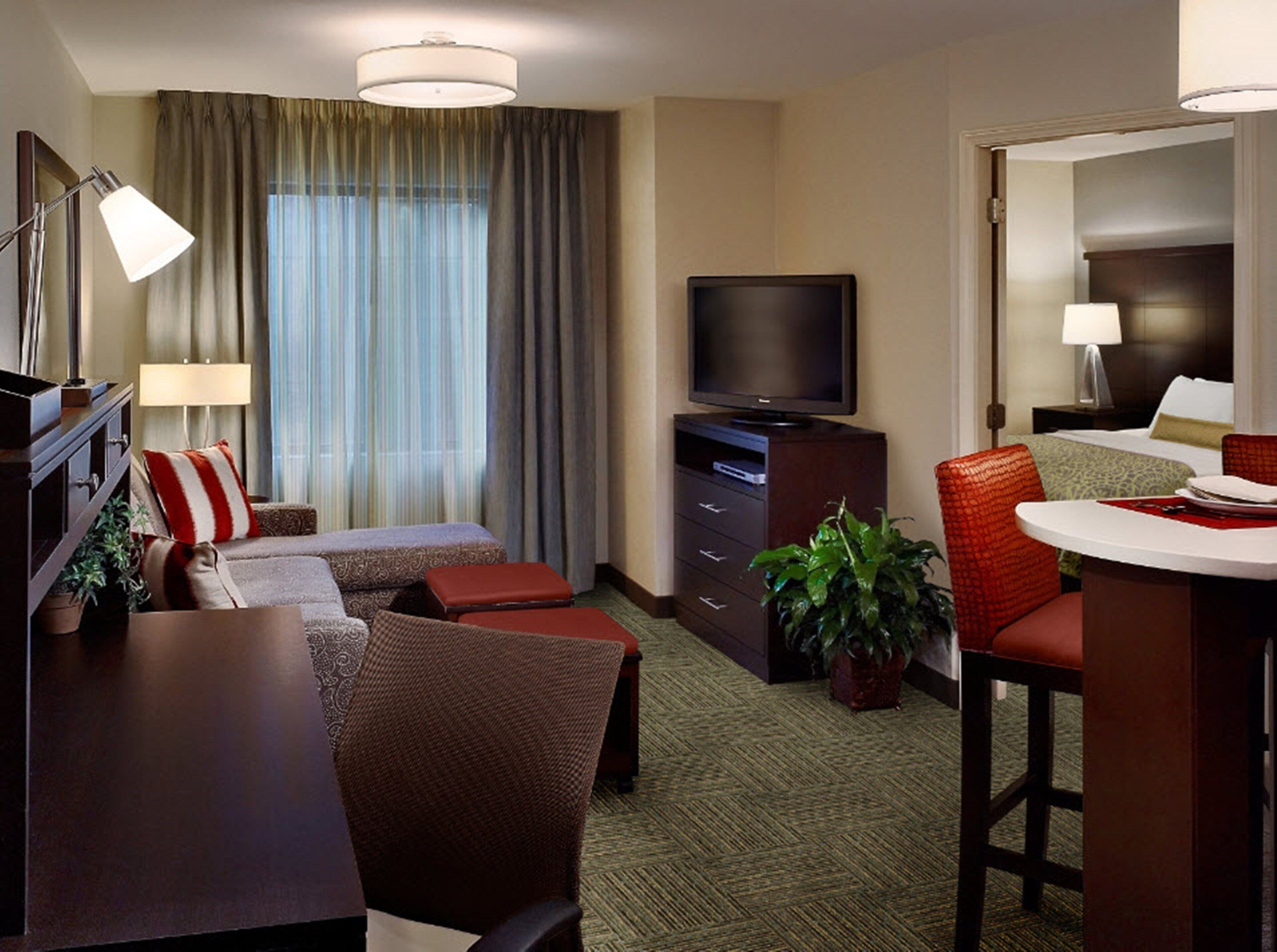Une chambre d’hôtel comprenant un lit, une télévision, un bureau et un coin repas.