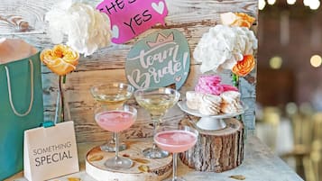 Ein Tisch mit einem Schild 'Team Bride!', einem Schild 'The Said Yes', einer Tasche mit der Aufschrift 'Something Special' und einer Torte auf einem Holzständer.