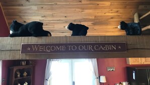 A cabin interior with a wooden ceiling, a welcome sign, and three bears on the ceiling. - Enjoy private...beautiful… large house with outdoor hot tub and sauna ! (Slaty Fork)