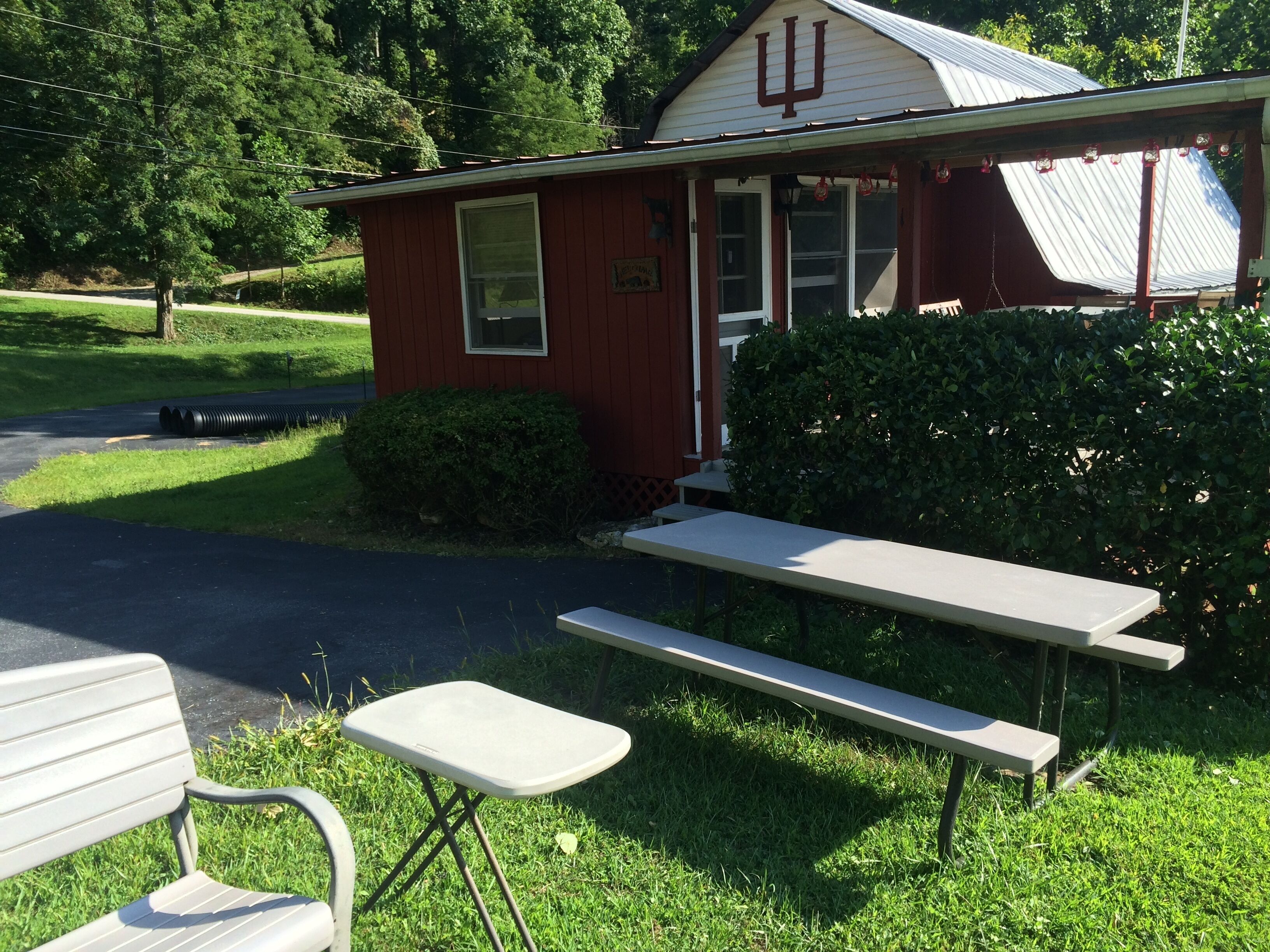 A red building with a large 'U' on the roof, a picnic table, and a bench.