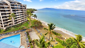 A hotel with a pool, beach, and ocean view.