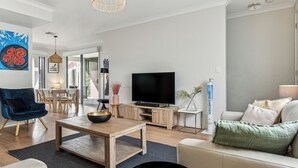 A modern living room with a wooden coffee table, a TV, and a sofa.