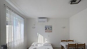 Un dormitorio con cama, escritorio, silla y mesa de comedor.
