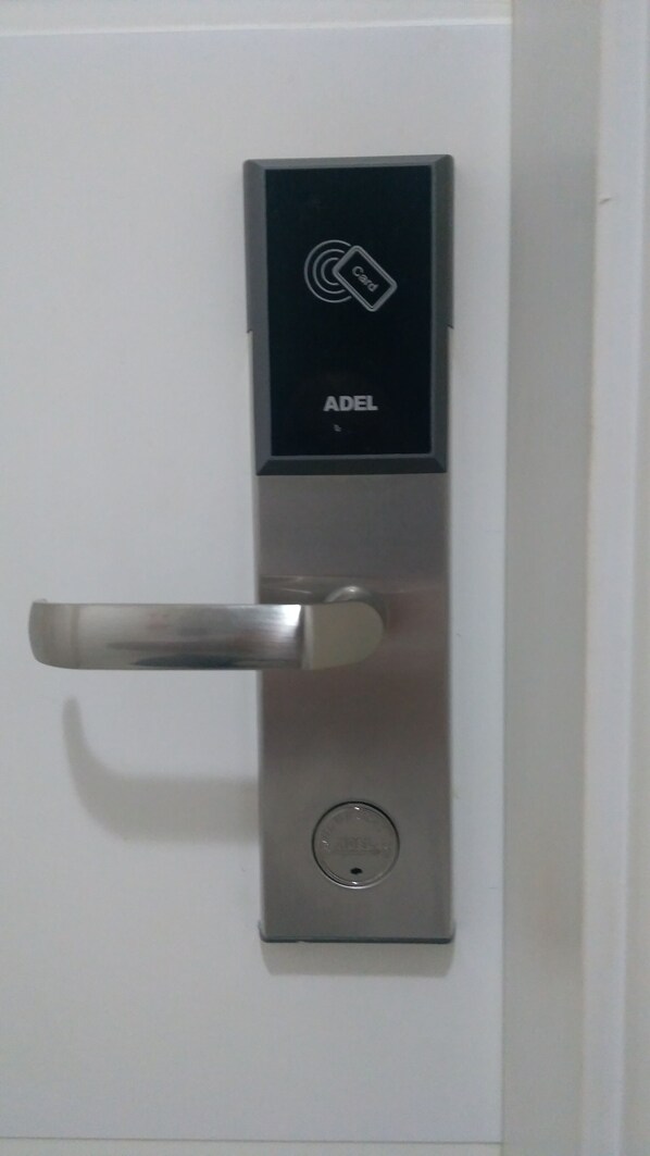 A modern door with a card reader and a keyhole.