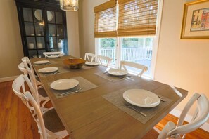 Enjoy meals with family and friends at this dining area, featuring a long table and comfortable seating for six.