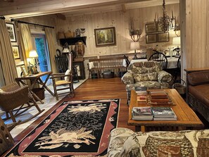 A cozy living room with a fireplace, wooden furniture, and a large rug. - Four Seasons Private Suite on Chestnut Ridge in Highlands - Private Club Access (Highlands)