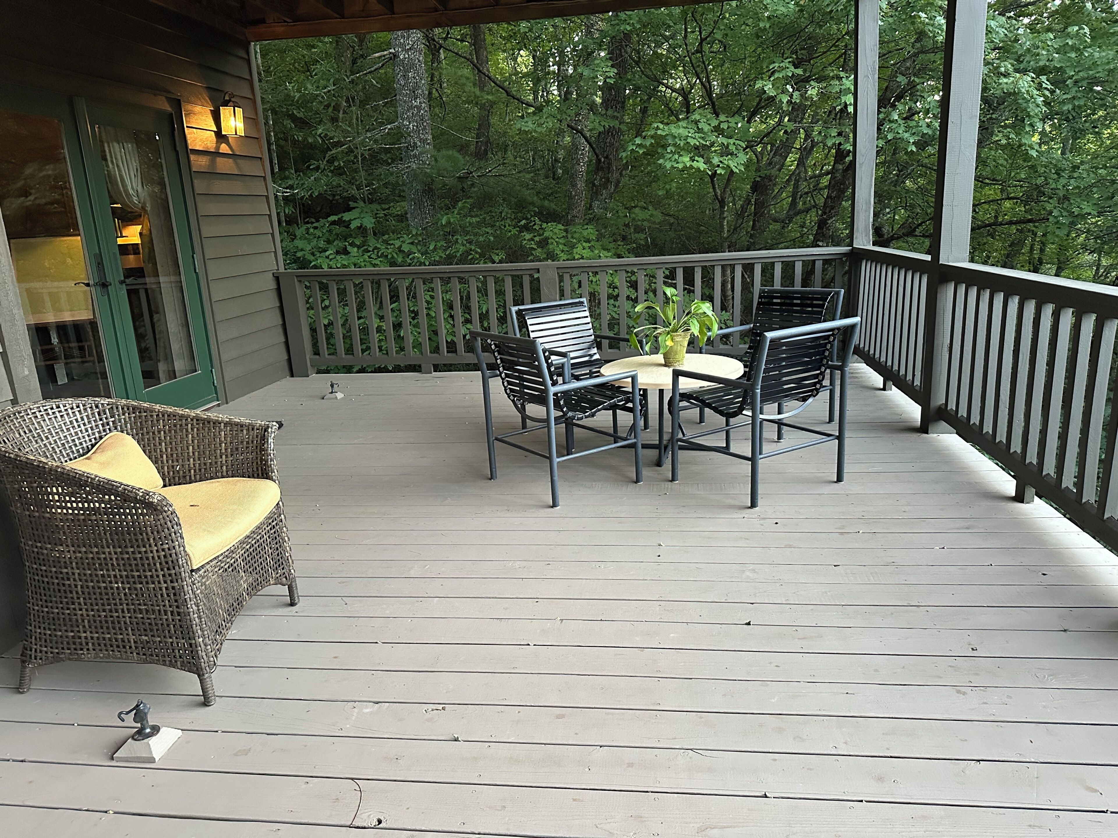 Une terrasse en bois, dotée de meubles d’extérieur et d’une rambarde.