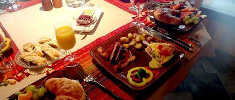 Un bufé de desayuno con diversos platos, incluyendo pasteles, frutas y una opción caliente con huevos y tocino.