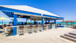 Een strandbar met terras en uitzicht op de oceaan.