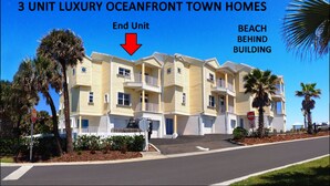 A 3-unit luxury oceanfront townhouse with a balcony, located behind a beach building. - •Townhome with Direct Beach Access •Sleeps 10 •4BR 3BA •Steps to Flagler Ave (New Smyrna Beach)