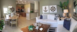 Relax in this stylish living room with a sofa, coffee table, and dining area.