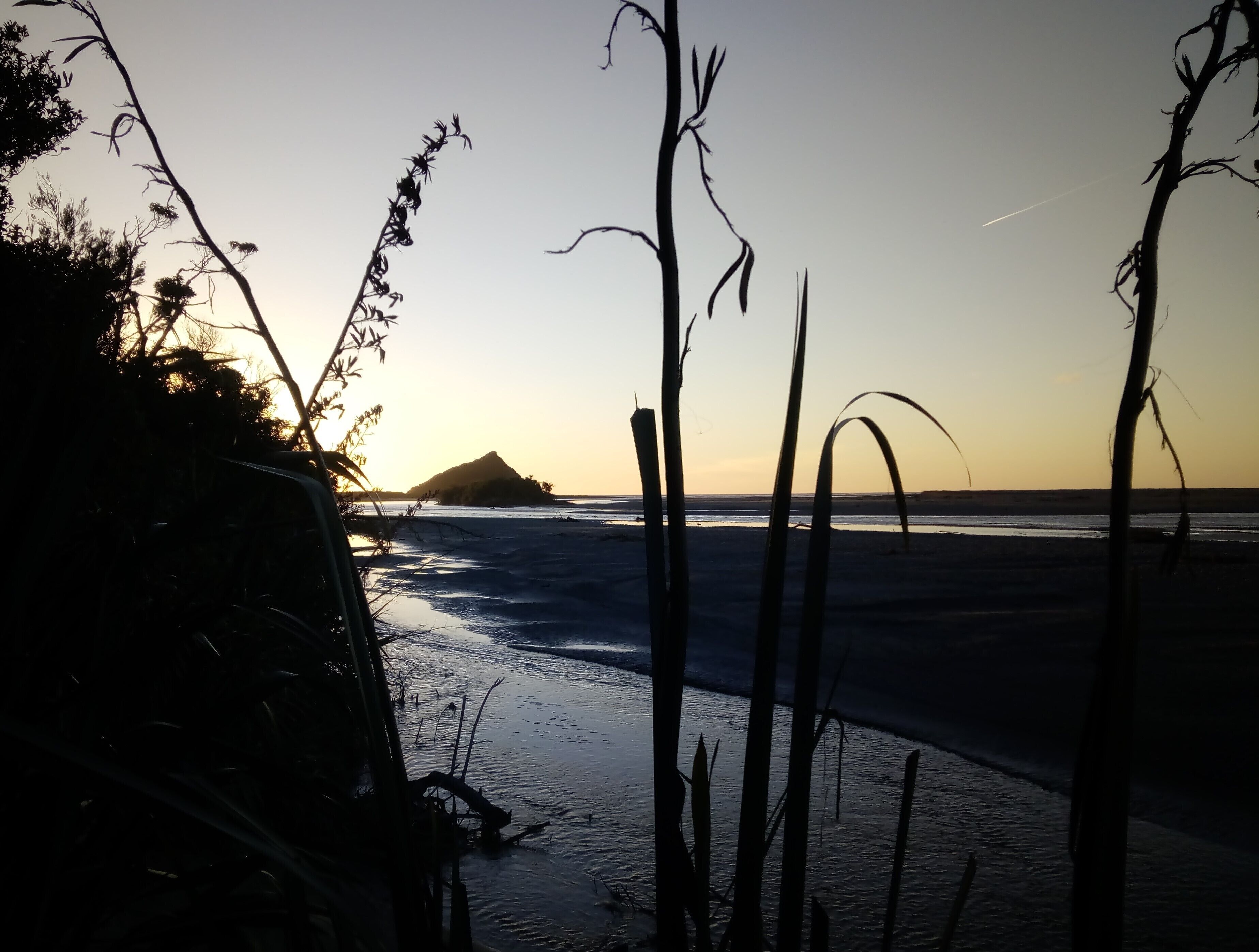 Eine Strandansicht mit einem Bergpanorama im Hintergrund.
