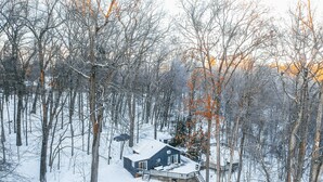 Una cabaña rodeada de árboles cubiertos de nieve.