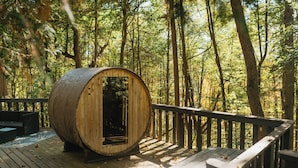 Una estructura de barril de madera en un muelle rodeado por un bosque.
