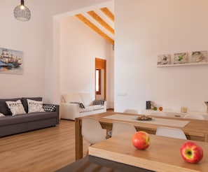 Een moderne woonkamer met een bank, eettafel en appels op tafel.