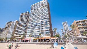 A high-rise hotel with multiple floors, a beachside location, and a pedestrian walkway. - Los Gemelos 21-B (Benidorm)