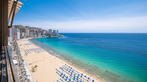A coastal cityscape with a beach, clear blue waters, and high-rise buildings in the background. - Los Gemelos 21-B (Benidorm)