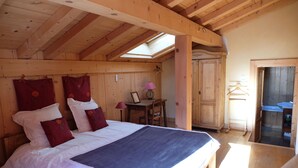 Un dormitorio de madera con cama, escritorio y baño.