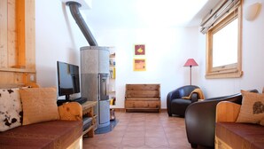 Una sala de estar acogedora con chimenea, muebles de madera y un televisor.