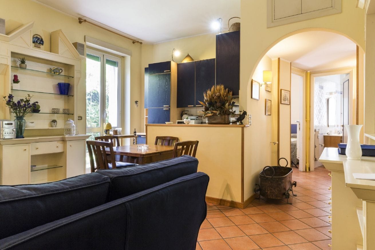 Une cuisine avec un coin repas, un canapé et une poubelle.