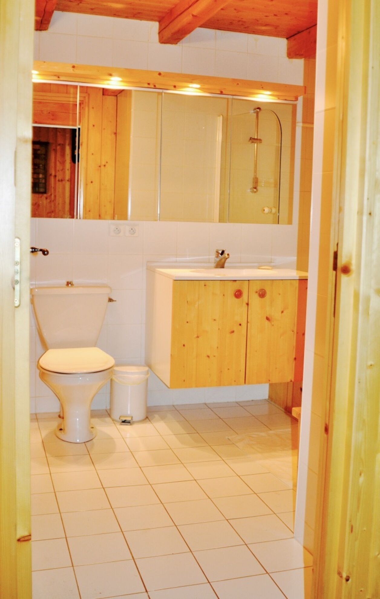 Un baño pequeño con inodoro, lavabo y armarios de madera.