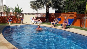 A swimming pool with clear water, surrounded by a fence and palm trees. - Résidence Chez Nous,, Deluxe Studios (50 M²) with hotel service + pool  (PHUKET)