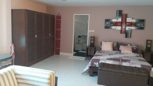 A bedroom with a bed, a sofa, a wardrobe, and a door leading to another room. - Résidence Chez Nous,, Deluxe Studios (50 M²) with hotel service + pool  (PHUKET)