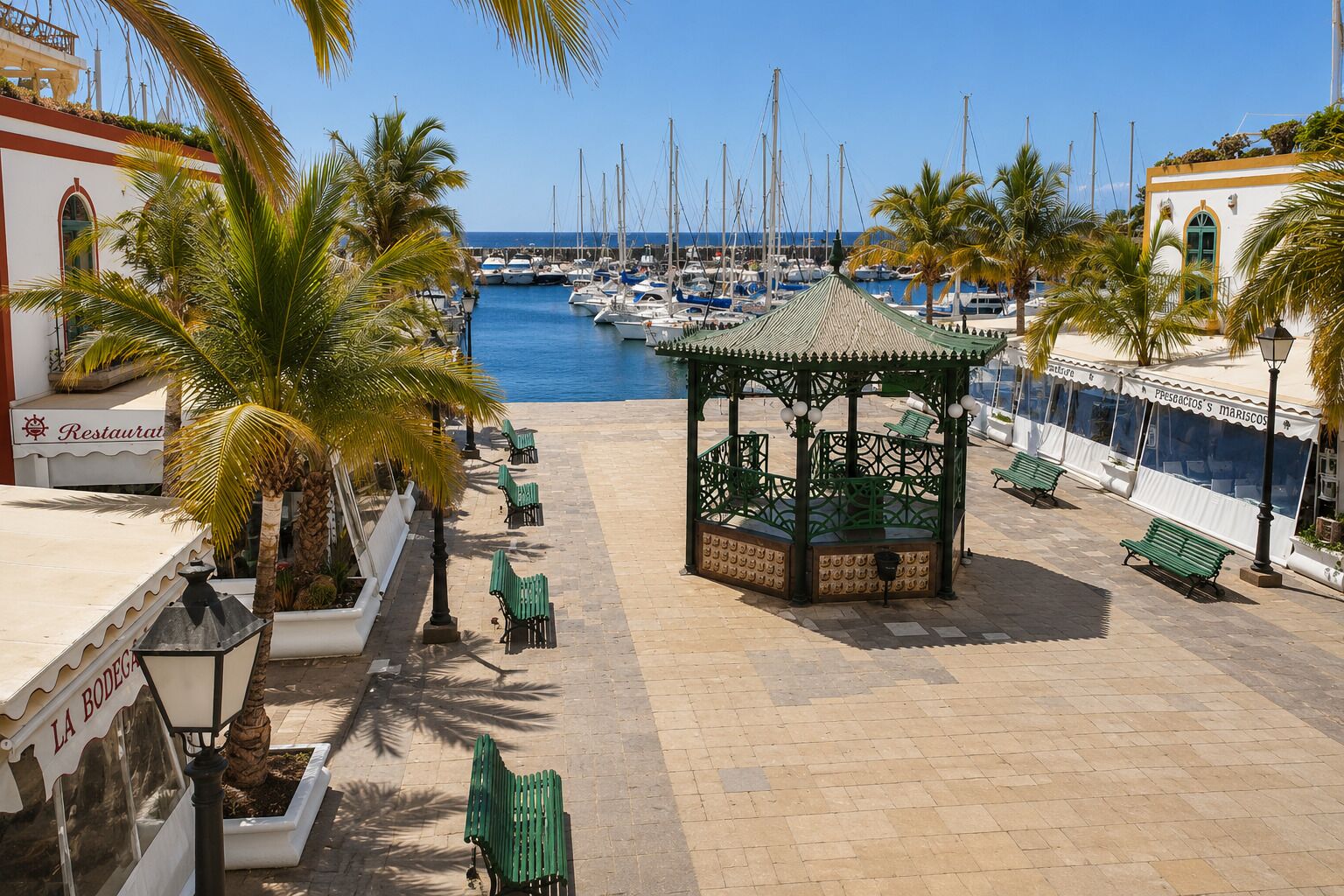 A marina with boats, a gazebo, palm trees, and a restaurant named 'LA BODEGA'.