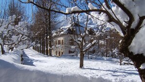 A snow-covered landscape with a building in the background.