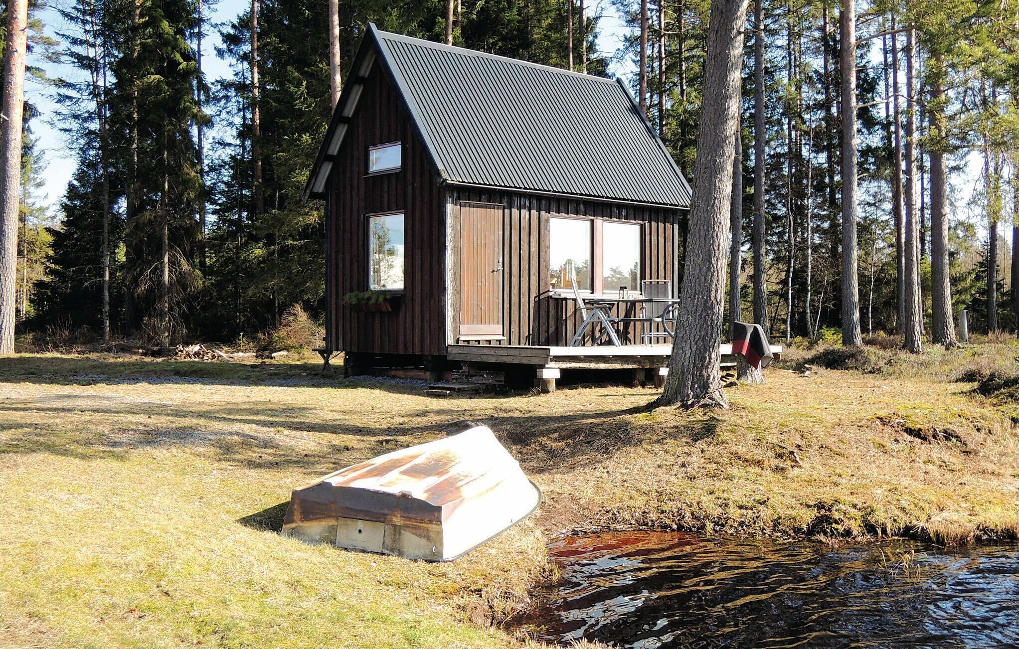 A rustic cabin with a sloped roof, large windows, and a deck.