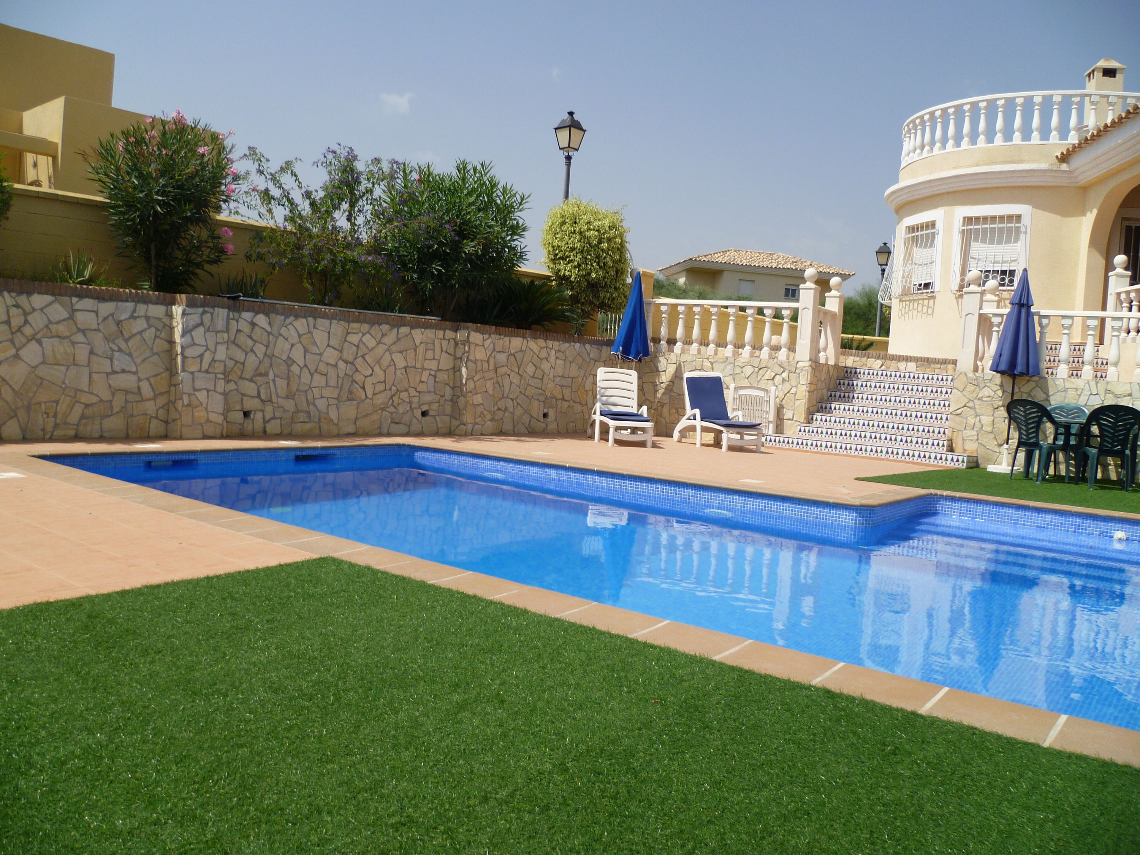 Una piscina al aire libre, tumbonas