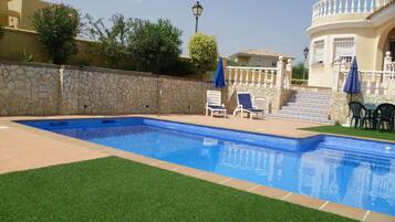 Una piscina al aire libre, tumbonas