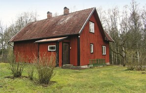A red wooden house with a gabled roof, a front door, and a small porch. - Cozy home in Långaryd with kitchen (Långaryd)