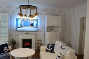 Flat-screen TV, fireplace, books