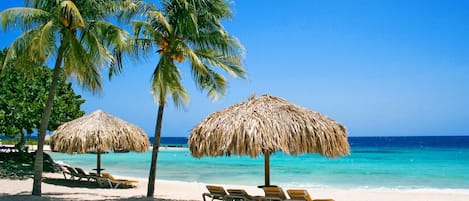 Una playa cerca, sillas reclinables de playa, toallas de playa