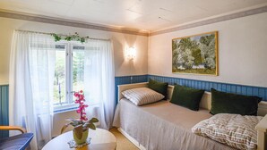 A cozy room with a bed, a table with a plant, and a window with curtains. - Lovely home in Tived with WiFi (Tived)