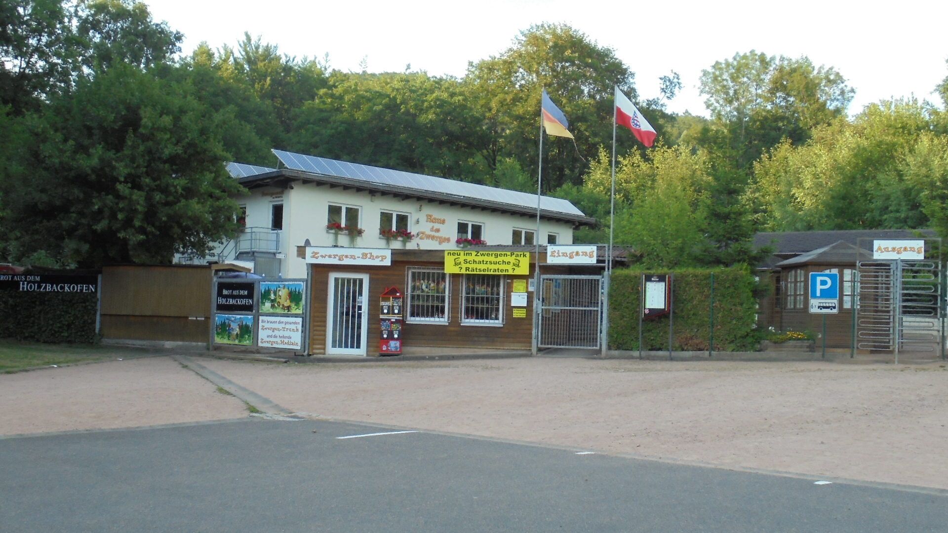 En byggnad med en skylt som visar texten ”Zwergen-Shop” och en parkeringsskylt.