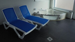 A bathroom with two blue sun loungers, a white bathtub, and a window providing natural light. - New vacation home with indoor pool in the beautiful Thuringian Forest on the Rennsteig (Trusetal)