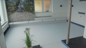 A room with a mural of a waterfall, a window with blinds, a radiator, and a potted plant. - New vacation home with indoor pool in the beautiful Thuringian Forest on the Rennsteig (Trusetal)