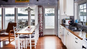 Une cuisine compacte avec vue sur un lac, un plancher en bois et les équipements de base.